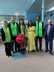 Group of six people stand together smiling at the camera. From the left they are: Support worker Emily, police officer Taryn Trevelion, Shadow Minister for Multicultural South Australia Jing Lee, JFA Purple Orange Project Officer Esther Simbi, Denis Yengi, and Mohan Bhattarai.