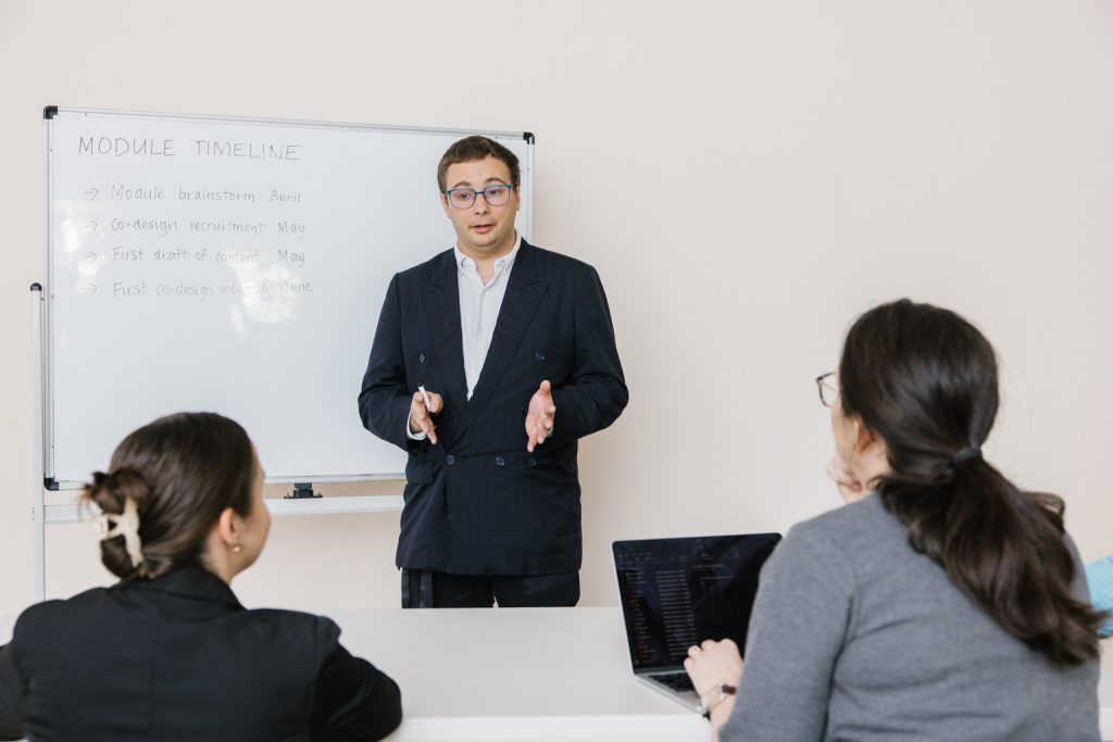 A man in a business suit presents to a group of people